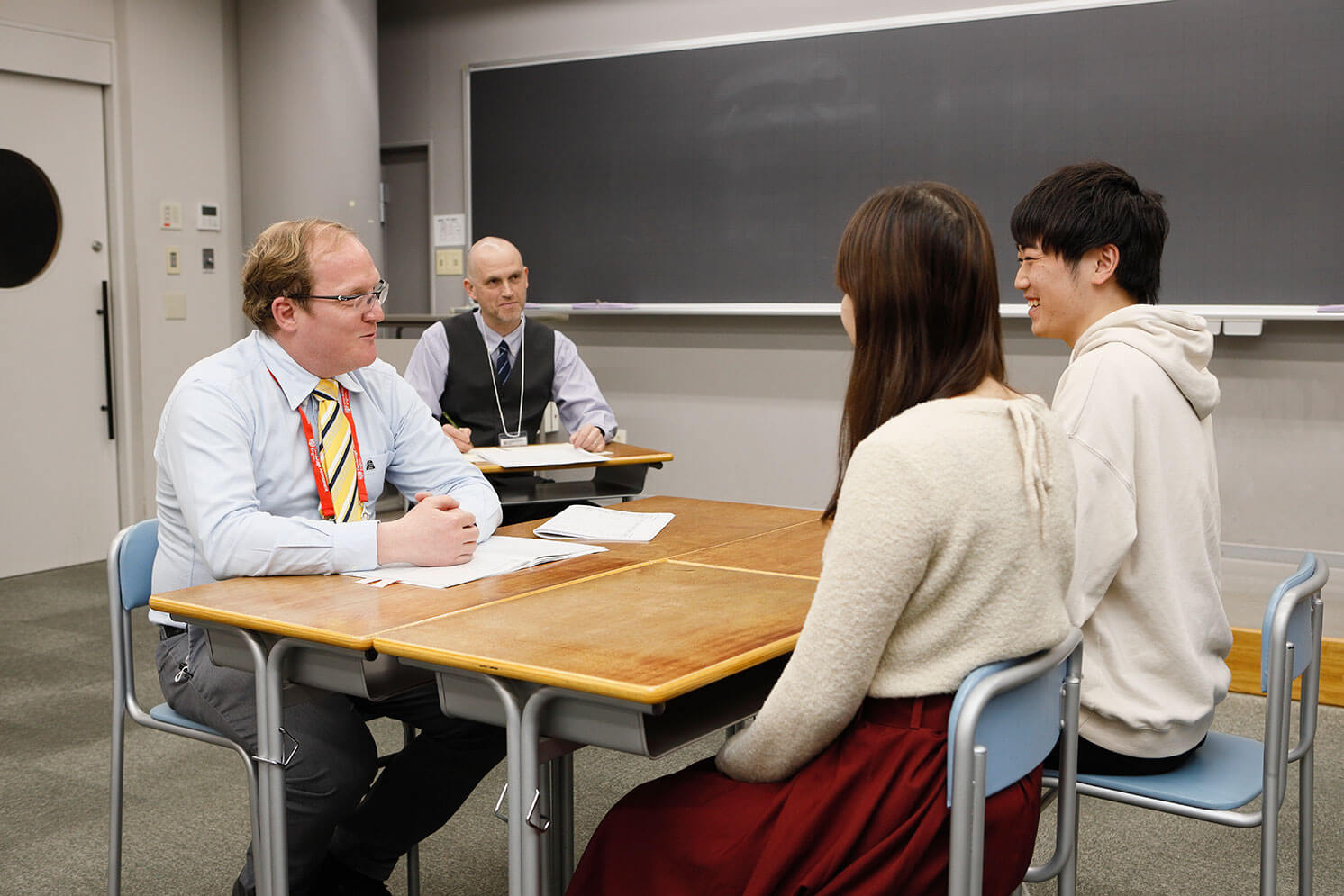 面接官２名と受検者２名がスピーキングテスト中の写真。